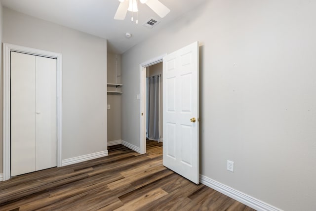 unfurnished bedroom featuring ceiling fan, dark hardwood / wood-style flooring, and a closet