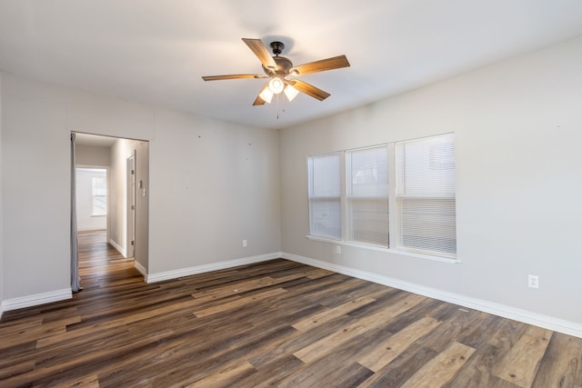 unfurnished room with ceiling fan and dark wood-type flooring