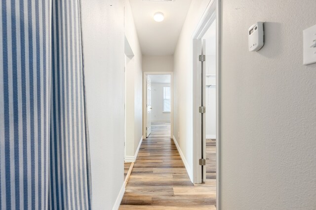 corridor with hardwood / wood-style floors