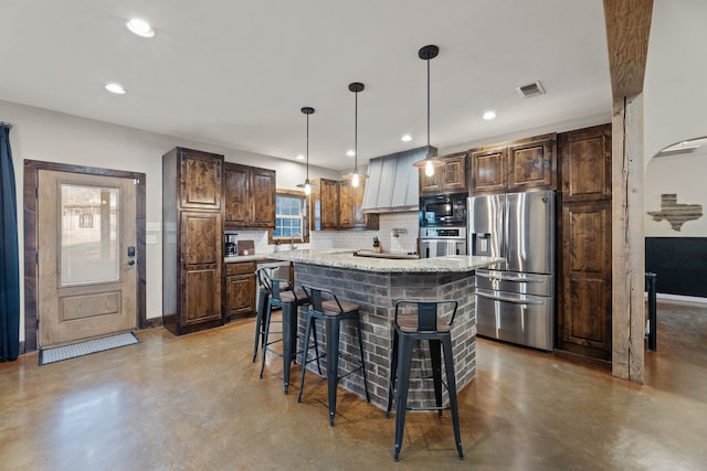 kitchen featuring decorative backsplash, appliances with stainless steel finishes, a breakfast bar, pendant lighting, and a center island