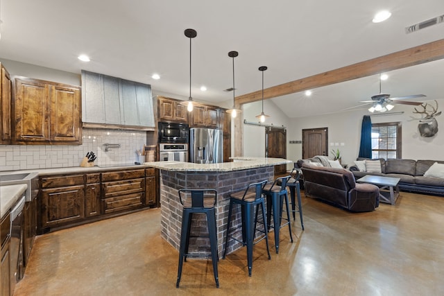 kitchen with a center island, stainless steel appliances, tasteful backsplash, decorative light fixtures, and a kitchen bar