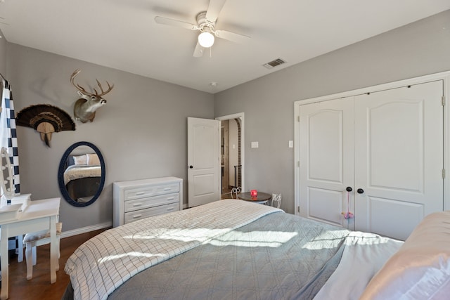 bedroom featuring dark hardwood / wood-style flooring, a closet, and ceiling fan