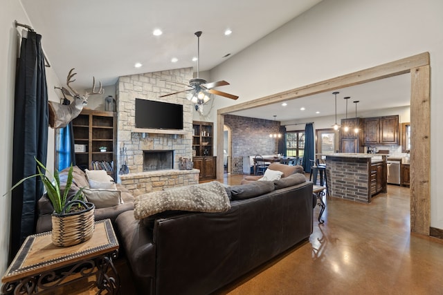 living room with ceiling fan, a fireplace, and a high ceiling