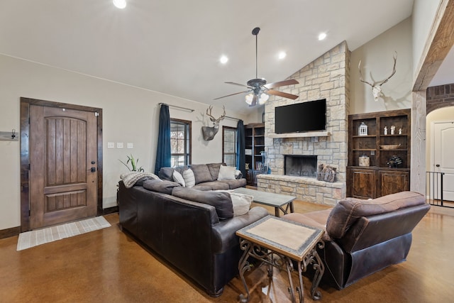 living room with lofted ceiling, ceiling fan, built in shelves, a fireplace, and concrete floors