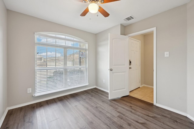 empty room with wood-type flooring and ceiling fan