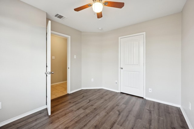 unfurnished bedroom with ceiling fan and dark hardwood / wood-style floors