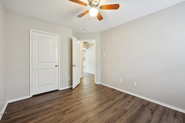 unfurnished bedroom featuring ceiling fan and dark hardwood / wood-style flooring