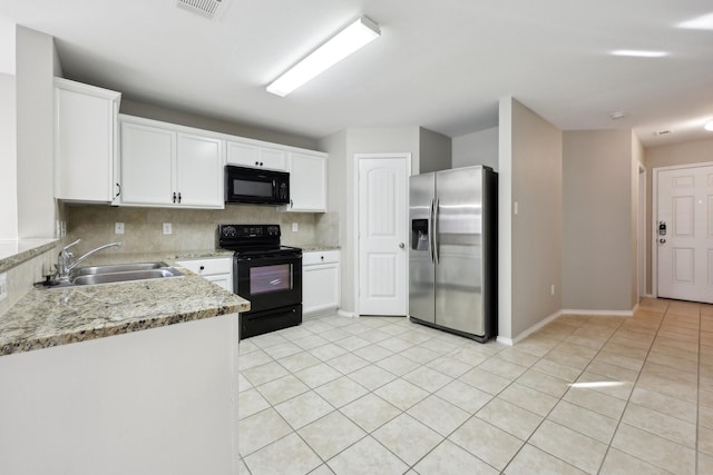 kitchen featuring sink, light tile patterned floors, light stone counters, white cabinets, and black appliances