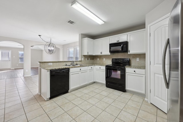 kitchen with kitchen peninsula, sink, black appliances, white cabinetry, and hanging light fixtures