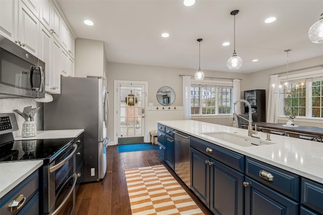 kitchen with dark hardwood / wood-style flooring, stainless steel appliances, sink, blue cabinetry, and white cabinets