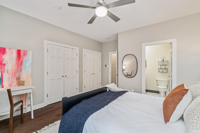 bedroom with two closets, ensuite bath, ceiling fan, and dark hardwood / wood-style floors