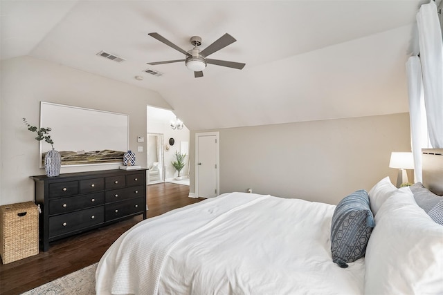 bedroom with vaulted ceiling, dark hardwood / wood-style flooring, and ceiling fan with notable chandelier