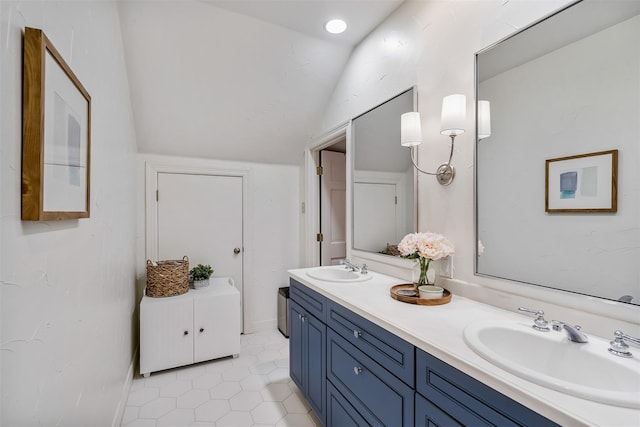 bathroom featuring tile patterned flooring, vanity, and lofted ceiling