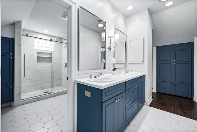 bathroom featuring tile patterned floors, a shower with door, and vanity