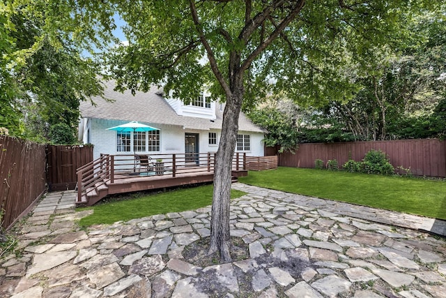 back of house featuring a lawn and a wooden deck