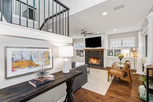 living room featuring a fireplace, hardwood / wood-style flooring, and ceiling fan