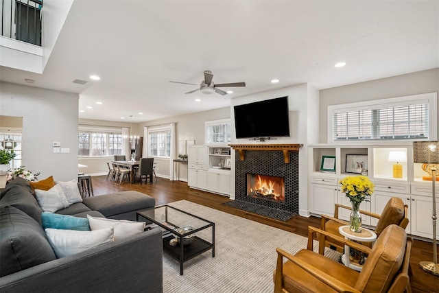 living room featuring a tiled fireplace, ceiling fan, and hardwood / wood-style floors