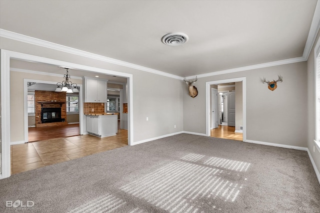 unfurnished living room with a brick fireplace, ornamental molding, and carpet