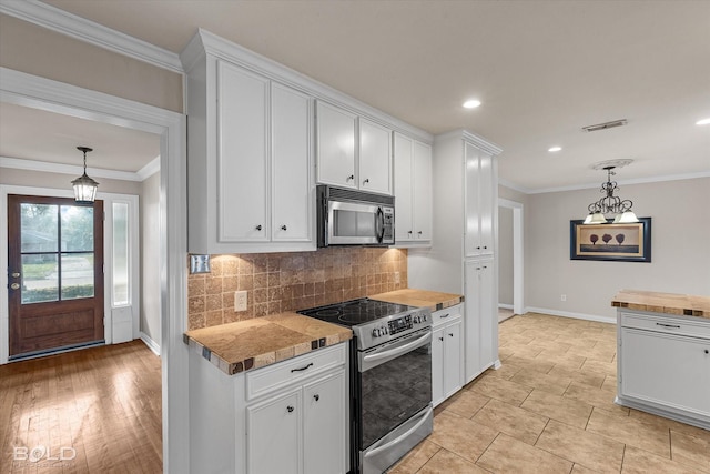 kitchen with stainless steel appliances, butcher block counters, and white cabinets