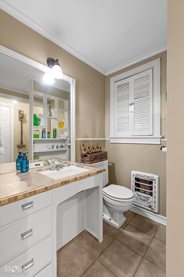 bathroom with heating unit, sink, tile patterned flooring, ornamental molding, and toilet