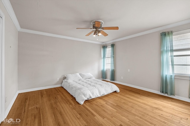 unfurnished bedroom featuring ceiling fan, light wood-type flooring, and crown molding