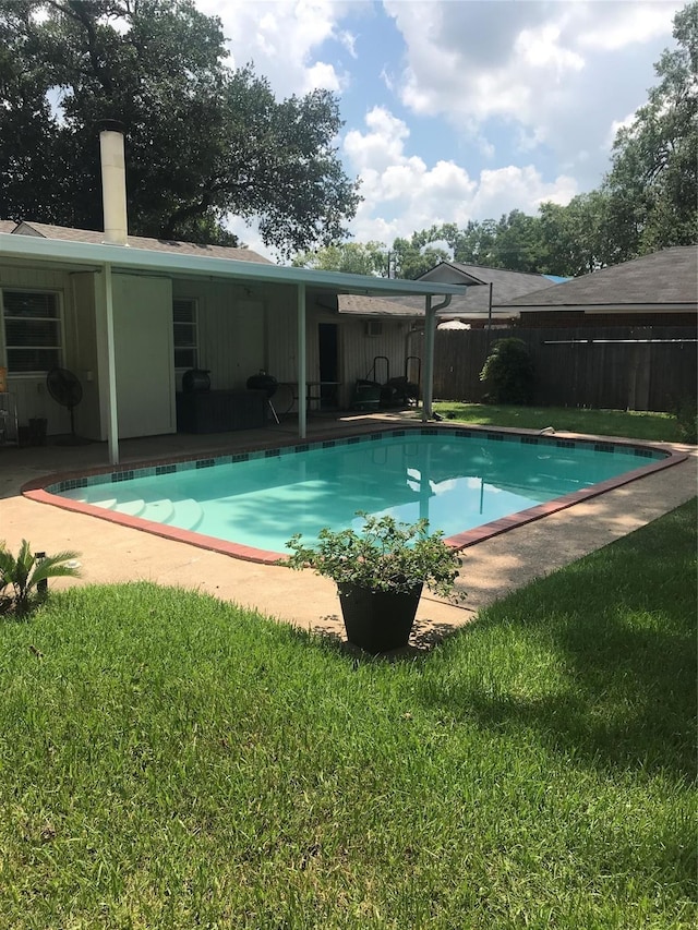 view of pool featuring a lawn and a patio area