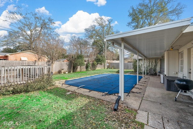 view of swimming pool featuring a patio area and a yard