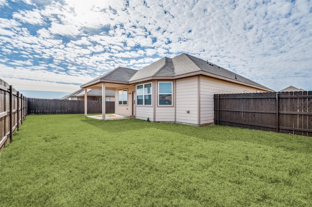 back of house with a patio area and a yard