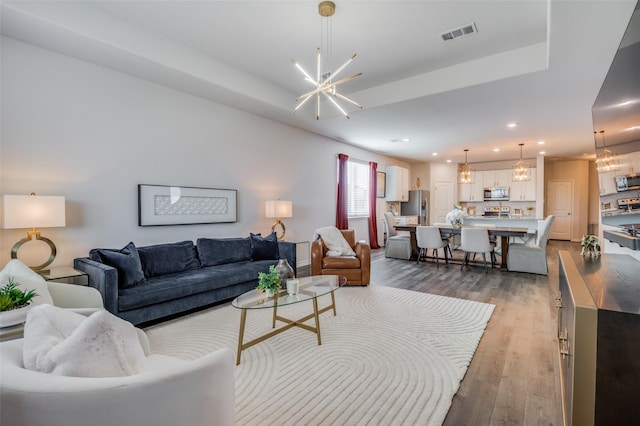 living room with hardwood / wood-style floors and a chandelier