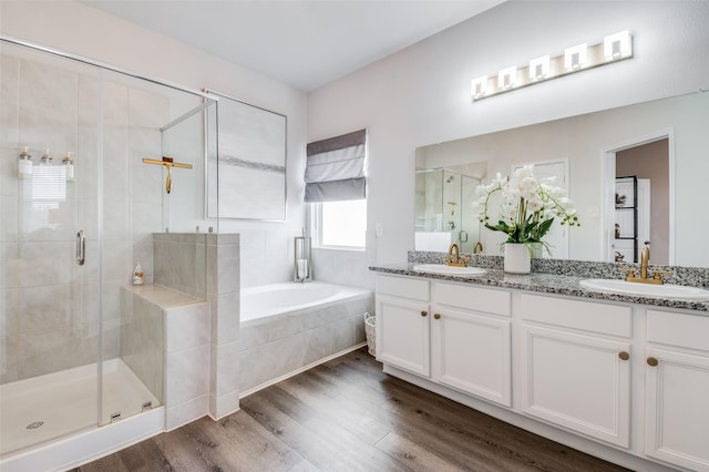 bathroom with hardwood / wood-style flooring, vanity, and shower with separate bathtub