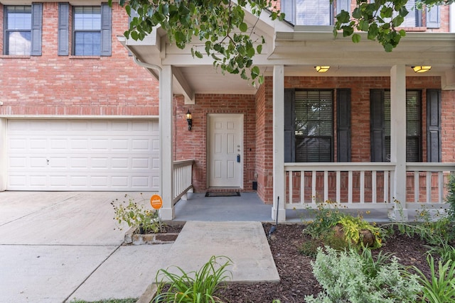 view of exterior entry with covered porch and a garage