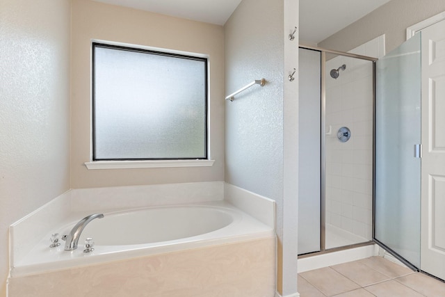 bathroom with tile patterned flooring, separate shower and tub, and a healthy amount of sunlight