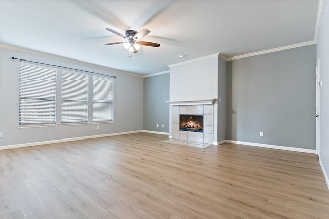 unfurnished living room featuring a tile fireplace, ceiling fan, light hardwood / wood-style flooring, and ornamental molding