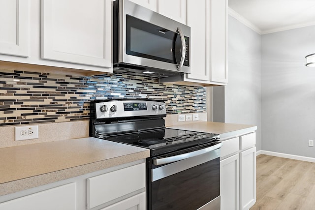 kitchen featuring white cabinetry, backsplash, and appliances with stainless steel finishes