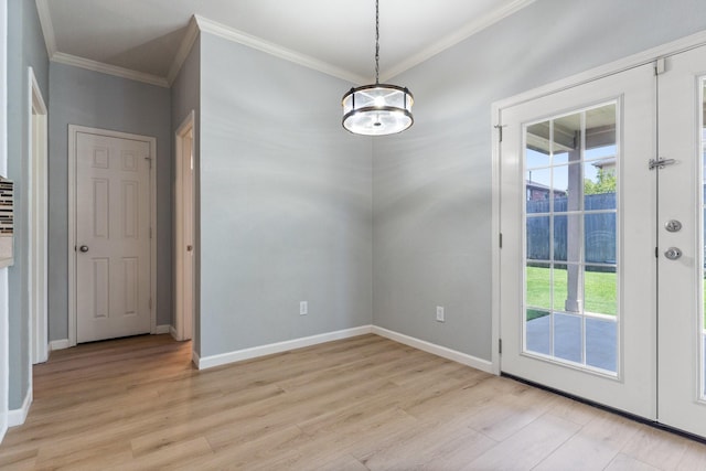 entryway with a chandelier, light wood-type flooring, and ornamental molding