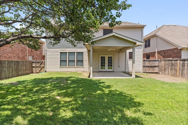 back of house with ceiling fan, a patio area, a yard, and french doors