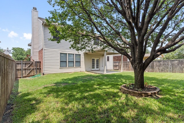 rear view of house with a yard, a patio area, and french doors