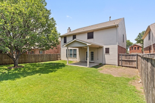 rear view of property with a yard, ceiling fan, and a patio area