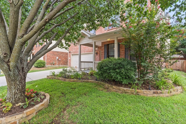 view of property hidden behind natural elements with a front yard and a garage