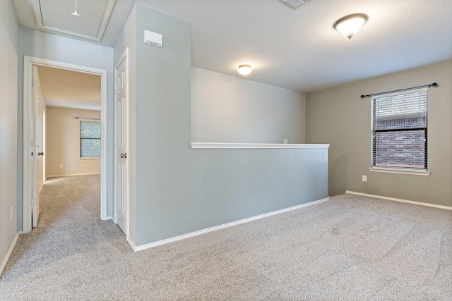 unfurnished room with a wealth of natural light and light colored carpet