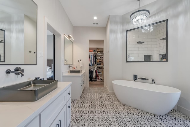 bathroom featuring independent shower and bath, vanity, and a chandelier