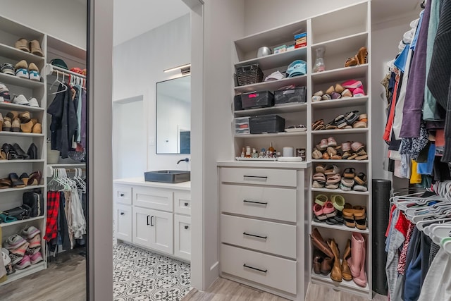 walk in closet featuring sink and light hardwood / wood-style flooring