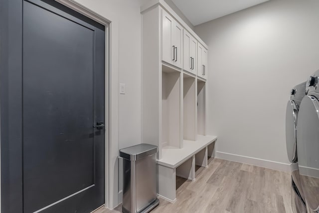 mudroom with separate washer and dryer and light hardwood / wood-style flooring