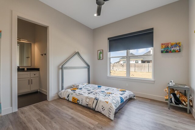 bedroom with ensuite bath, ceiling fan, and light hardwood / wood-style flooring