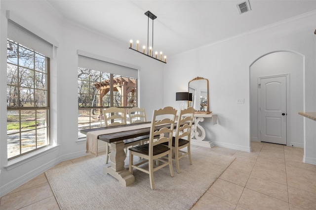 tiled dining area with ornamental molding and a notable chandelier