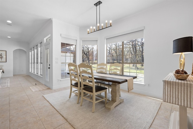 dining room featuring a notable chandelier, light tile patterned flooring, and ornamental molding