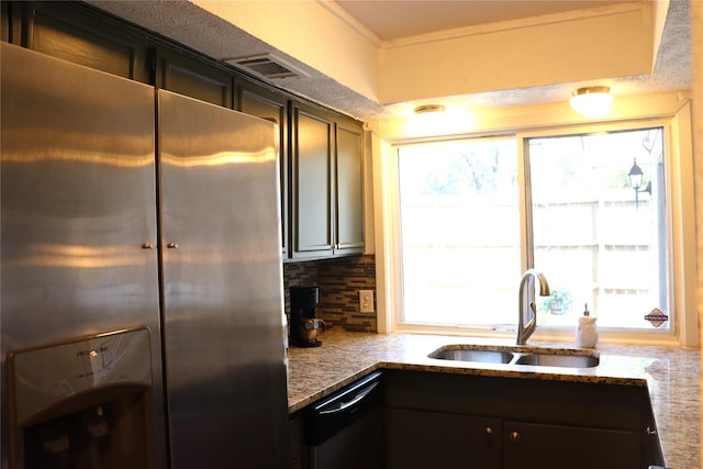 kitchen featuring stainless steel refrigerator with ice dispenser, dishwashing machine, tasteful backsplash, stone counters, and sink