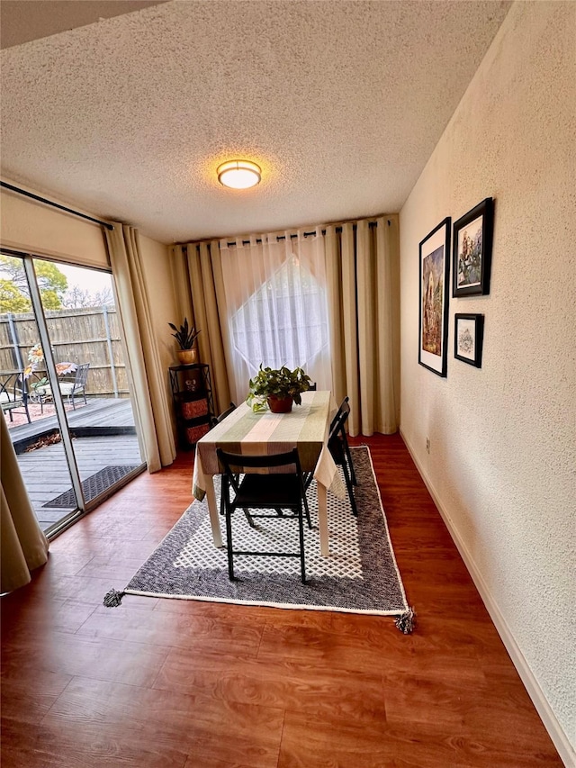 dining room featuring a textured ceiling and hardwood / wood-style floors