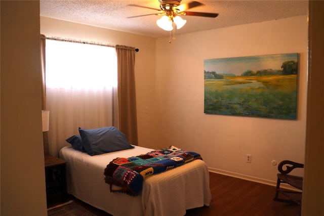 bedroom featuring ceiling fan, a textured ceiling, and dark hardwood / wood-style flooring