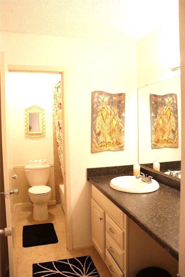 full bathroom featuring toilet, tile patterned floors, vanity, and shower / bath combo with shower curtain